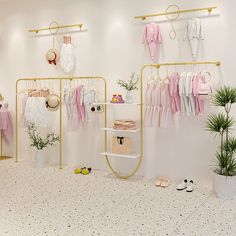 a room with clothes and shoes hanging on the wall next to a potted plant