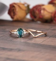 a close up of a ring on a wooden surface with roses in the back ground