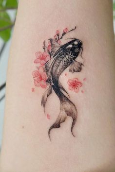 a goldfish tattoo on the ankle with flowers and leaves around it's neck