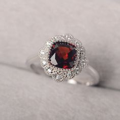 ◆ The ring is handcrafted from sterling silver and decorated with a dazzling 7*7 mm garnet and cluster CZs. It is suitable for engagement/anniversary/daily occasion. ◆ Production Description: Main stone Type: Garnet Main Stone Shape: Cushion cut Main Stone Size: 7*7 mm(1.76ct) Side stone: CZ Metal: 925 Sterling silver - Other options available in the drop down menu ◆ Customization: √Add Engraving √Other Metal Type Available √Other Gemstones & Shapes Available √Personalization Requests Availa Elegant Garnet Cluster Ring With Birthstone, Elegant Garnet Birthstone Cluster Ring, Elegant Diamond Flower Ring With Birthstone, Elegant Flower Ruby Ring For Formal Occasions, Round Garnet Cluster Ring For Anniversary, Elegant Garnet Cluster Ring For Anniversary, Elegant Garnet Rings With Brilliant Cut, Elegant White Gold Flower Ring With Birthstone, Elegant Sterling Silver Flower Ring With Birthstone