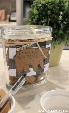 a glass jar filled with lots of peanuts and a bear cut out on the side