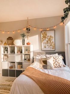 a bedroom with lights strung from the ceiling and bed in front of a bookcase