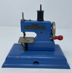 a blue sewing machine with red handle on a white background