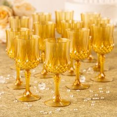 many yellow wine glasses are lined up on the table