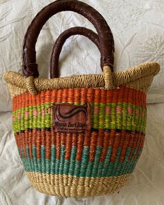 This beautiful handmade Bolga market basket can be presented to any Stylish woman  One of those Picnic Basket to have in summer time Stylish handmade straw bag has made women to take a look at it .  The basket bag suits women who love fashion and trendy woven statement pieces  The bag portrays highly handmade woven skills due to its color and the coordinated patterns  8 " long  inches might be slightly higher or lower . Top width and bottom width is 12 inches Quantity:  1 basket Approximate meas Multicolor Basket Crochet Bag Casual Style, Multicolor Basket Crochet Bag, Casual Multicolor Crochet Basket Bag, Artisan Multicolor Straw Bag As Gift, Artisan Multicolor Handmade Beach Bag, Artisan Multicolor Straw Bag For Gift, Traditional Multicolor Straw Bag For Gifts, Bucket Straw Bag With Weaving For Market, Weaving Straw Bucket Bag For Market