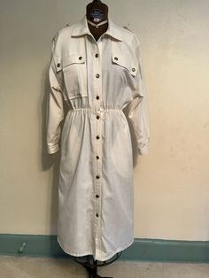 "Vintage 1980's white dress.  'Little g' brand from Brainerd, Minn. Has elastic waist and front pockets.  Padded shoulders and decorative buttons.  Two small spots. Measurements: Bust: 17\" Waist: 26\" stretches to 38\" Sleeve: 19\" Waist to hem: 26\"" White Button-up Shirt Dress With Pockets, Classic White Shirt Dress For Fall, White Long Sleeve Shirt Dress With Button Closure, White Button Closure Shirt Dress For Fall, White Button Shirt Dress For Fall, White Single-breasted Dress For Fall, White Single Breasted Dress For Fall, White Retro Dress With Button Closure, Vintage Long Sleeve Shirt Dress For Work