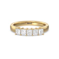 a yellow gold ring with five princess cut diamonds