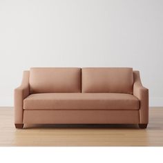 a couch sitting on top of a hard wood floor next to a white wall in an empty room