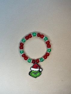 Adorable Grinch Bracelet - Perfect for Christmas and the Holidays! This charming bracelet features stunning red and green beads complemented by silver spacers. Festive Christmas Bracelets With Round Beads, Christmas Festive Round Beads Bracelets, Christmas Beaded Stretch Bracelet Gift, Festive Green Beaded Bracelets With Colorful Beads, Beaded Jewelry For Christmas Holiday, Festive Green Beaded Bracelets, Christmas Holiday Bracelets With Round Beads, Christmas Gift Bracelets With Colorful Beads, Christmas Holiday Beaded Bracelets With Colorful Beads