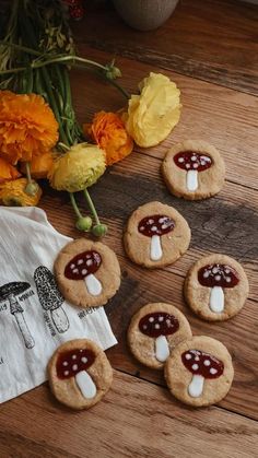 several cookies with marshmallows and jelly on them sitting on a wooden table