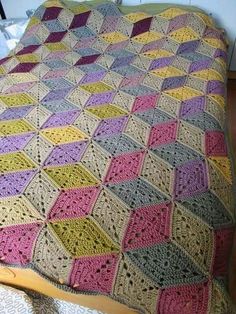 a crocheted blanket sitting on top of a bed