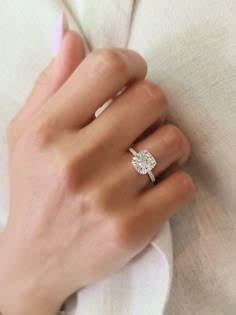 a woman's hand with a diamond ring on it