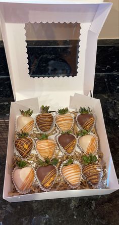 a box filled with chocolate covered strawberries on top of a counter