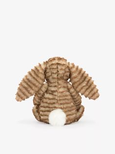 a brown and white stuffed animal sitting in front of a white background