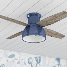 a blue ceiling fan mounted to the ceiling in a child's room with wallpaper