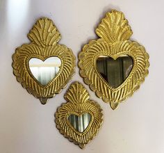 three gold heart shaped mirrors hanging on the wall