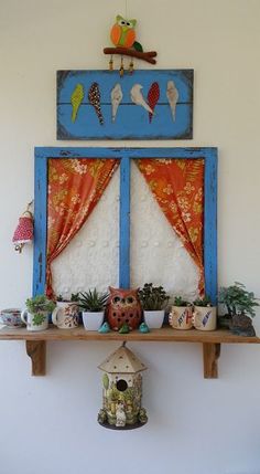 a shelf with potted plants in front of a window and birdhouse on top