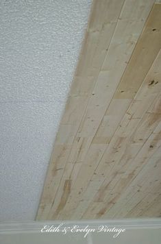 wood planks are being installed on the ceiling in this room with white walls and ceilings