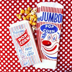 two bags of popcorn sitting on top of a red and white polka dot tablecloth