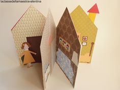 an open book with paper cut out of it's sides and a doll in the front