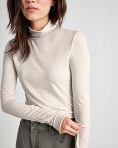 Our wear-anywhere Bamboo turtleneck is an essential-- with a bodycon fit and extra long sleeves that reach your thumbs for a cozy fit. Added spandex makes it hug the body, making it perfect for layering. Tuck it into anything-- jeans, skirts or joggers. Bamboo jersey Turtleneck Bodycon fit Winter Funnel Neck Turtleneck With Thumbholes, Winter Turtleneck With Thumbholes And Funnel Neck, Fitted Mock Neck Top For Winter, Fall Mock Neck Top With High Stretch, Fitted Basic Winter Tops, Winter Basic Fitted Tops, Winter Turtleneck Mock Neck Top With Thumbholes, High Stretch Mock Neck Top For Fall, Casual Solid Turtleneck With Thumbholes