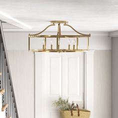 a chandelier hanging from the ceiling in a room with white walls and stairs