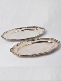 two silver serving trays on white background