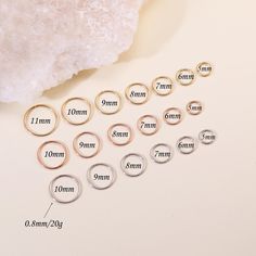 six different sizes of rings sitting on top of a white table next to a rock