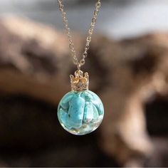 “Royal Turquoise Globe” Tumbled Natural Marbled Blue Stone Captured Caged Preserved Shards Fragments Chips Transparent Clear Orb Ball Gold Crown Regal Queen Princess Necklace. Beautiful Transparent Orb/Sphere With Preserved/Captured Natural Blue Tibetan Turquoise Tumbled Mini Stones With Brown Marbled Inclusions/Streaks. Atop The Globe Is A Tiny Ornate Gold Crown Which Gives The Pendant An Air Of Regality. On A Link Chain. New. Measurements: Pendant Length: 0.9” Pendant Width: 0.6” Chain Length: Queen Princess, Princess Necklace, Tibetan Turquoise, Gold Crown, Blue Stone, Link Chain, Chain Lengths, Chain Length, Blue Gold