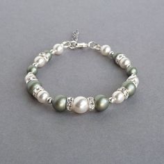 Dusty green and white Swarovski pearls have been combined with rings of Swarovski crystals to create these sage green pearl bracelets. Perfect gifts for bridesmaids in a celadon themed wedding. Each olive pearl and crystal bracelet measure 7 inches / 17.75cm in length and is finished with a silver plated lobster clasp. I have added a 1 inch extension chain to allow the wearer to adjust their single strand, celadon bracelet to fit. Your pistachio coloured jewellery will be carefully gift wrapped Dusty Green Wedding, Jewellery For Bridal, Green Pearl Jewelry, Green Wedding Jewelry, Bridesmaid Bracelets, Green Themed Wedding, Pearl Bracelets, Dusty Green, Pearl Jewelry Sets