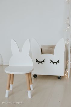 two white chairs with wooden legs and eyes on them