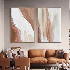 a living room filled with furniture and two paintings on the wall above it's coffee table