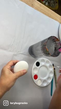 someone is painting an egg on a table