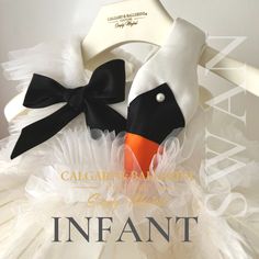 a white dress with black and orange bows on the neckline is featured in an advertisement for cajapari couture