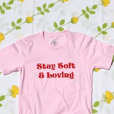 stay soft and loving tee Pink Relaxed Fit T-shirt For Streetwear, Pink Relaxed Fit T-shirt With Letter Print, Pink Slogan T-shirt With Short Sleeves, Trendy Pink T-shirt With Text Print, Casual Pink Slogan T-shirt, Pink Graphic Print T-shirt For Loungewear, Cute Pink T-shirt With Graphic Print, Pink Slogan T-shirt For Loungewear, Trendy Pink T-shirt With Screen Print