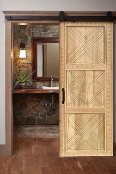 an open door leading to a bathroom with stone wall and wood flooring on the walls