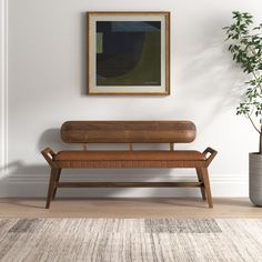 a wooden bench sitting next to a potted plant on top of a hard wood floor