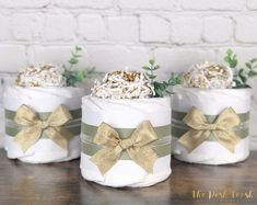 three baby diapers with bows on them are sitting on a table next to a brick wall