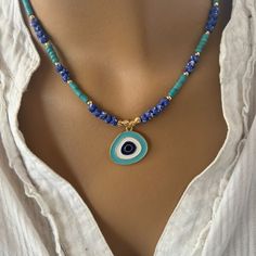 🌟 Elegance with a Protective Touch: Purple Hematite and Turquoise Evil Eye Necklace! 🌟 This exquisite necklace combines the sophistication of purple hematite and the vibrant charm of turquoise, adorned with an evil eye for added protection. Measuring 42 cm, it's perfect for any occasion.✨ Product Details: Length: 42 cm Material: Hematite Color: Multicolor Care Instructions: Avoid contact with perfume, water, and chemicals. Store in a pouch when not in use. Note: Colors may vary slightly due to Blue Beaded Turquoise Amulet Necklace, Blue Beaded Amulet Style Turquoise Necklace, Blue Gemstone Beads Amulet Necklace, Evil Eye Necklace, Eye Necklace, Evil Eye, Necklace Etsy, Aura, Violet