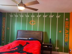 a bed room with a neatly made bed next to a ceiling fan and wallpaper