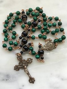 This rosary is handmade with 20 gauge bronze wire and chain, and bronze rosary medals. The stones are 6mm malachite gemstones and 8mm onyx gemstones. Spiritual Wire Wrapped Rosary As Gift, Spiritual Gift Wire Wrapped Rosary, Malachite 8mm Beads Jewelry Gift, Handmade Bronze Rosary As A Gift, Bronze Rosary As Gift, Spiritual Wire Wrapped Crucifix Jewelry, Bronze Rosary With Round Beads As Gift, Gold Gemstone Beads Rosary, Green Beaded Rosary With Round Beads