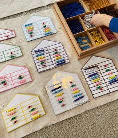 a child is playing with some sort of building blocks and beads in a box on the floor