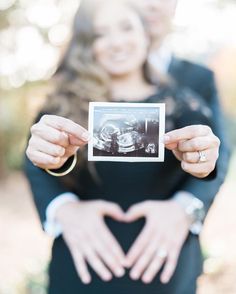 a woman holding up a photo in front of her heart