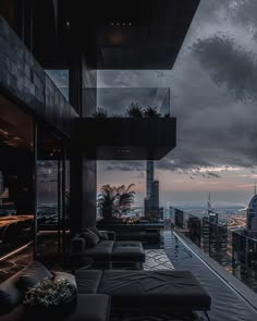 an outdoor lounge area overlooking the city at dusk with dark clouds in the sky above