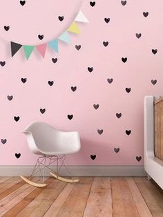 a baby's room with pink walls and black hearts on the wall