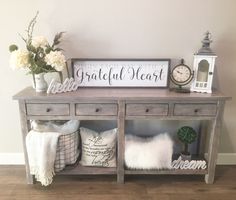 a wooden table topped with pillows and a clock