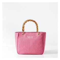 This stunning summer-inspired handbag, now in a compact, vacation-ready size, is crafted from a durable raffia-inspired fabric with polished bamboo handles. Lined in cotton with three interior pockets and polished bamboo handles, the classic silhouette is both simple and elegant, polished enough for formal occasions and relaxed enough for everyday use. Embroider a monogram to add a personal touch to this luxe gift for yourself or your favorite person.    12" w (bottom) x 5" d x 10.5" h  Handle d Chic Beach Bag With Bamboo Handle For Travel, Elegant Bag With Bamboo Handle For Vacation, Elegant Vacation Bag With Bamboo Handle, Elegant Everyday Straw Bag With Bamboo Handle, Summer Beach Bag With Bamboo Handle For Everyday, Top Handle Beach Bag With Bamboo Handle For Shopping, Summer Bags With Bamboo Double Handle, Summer Travel Straw Bag With Canvas Material, Summer Canvas Bags With Rolled Handles