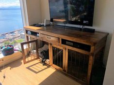 a flat screen tv sitting on top of a wooden entertainment center next to a window