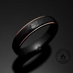 a black and gold wedding ring on a dark background