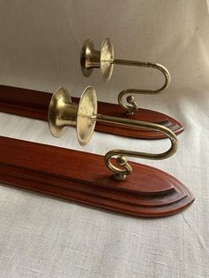 two brass - plated musical instruments on wooden stands